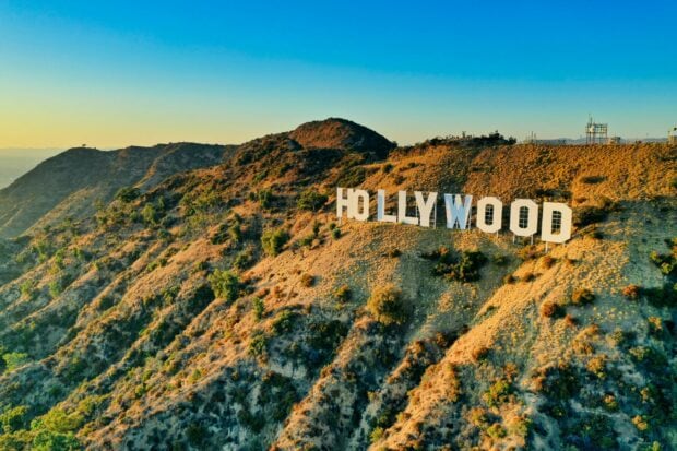 A scenic view of the Hollywood sign on the hills during sunset light