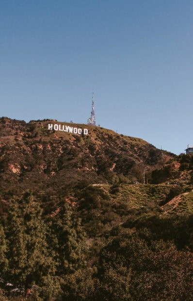 View of the Hollywood sign on a sunny day with clear blue sky and surrounding hills