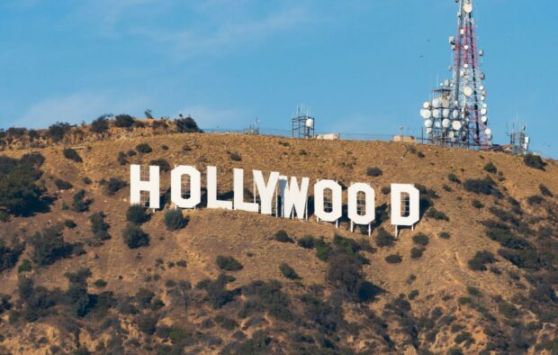 View of the Hollywood sign on a hill with communication towers in the background