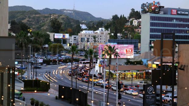 Scenic view of Hollywood Sign with busy street and city buildings in Los Angeles