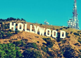 The famous Hollywood Sign on the hillside surrounded by dry vegetation and communication towers