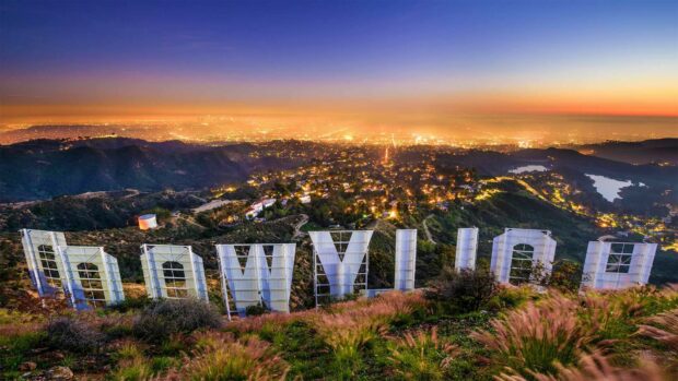 View of Hollywood Sign in the hills overlooking the city at sunset with vibrant sky