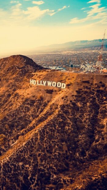 Aerial view of the Hollywood sign on a mountain with cityscape in the background