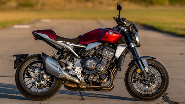 A red Honda CB1000R is parked on a road with a blurred natural background, HD Desktop Wallpaper