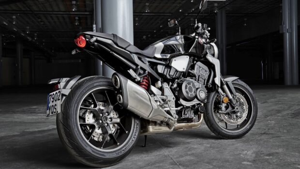 A sleek Honda CB1000R motorcycle parked in a dark garage with detailed engine and tires visible, HD Desktop Wallpaper