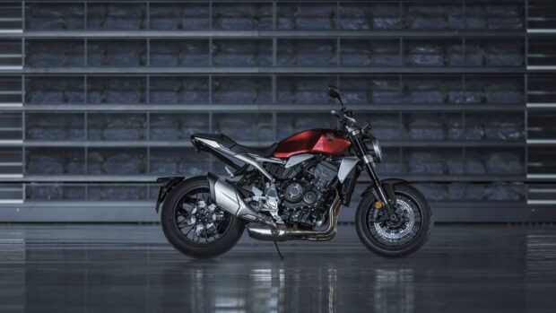 A red Honda CB1000R motorcycle is parked indoors with a reflective floor, HD Desktop Wallpaper