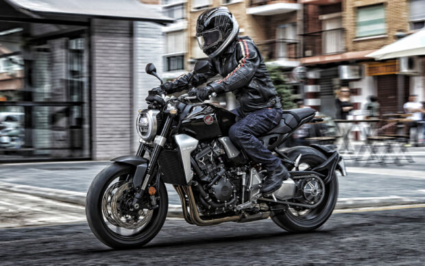 A person riding a Honda CB1000R motorcycle in the city street with motion blur, 2K Desktop Wallpaper
