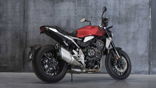 A red Honda Cb1000R motorcycle parked indoors against a gray wall, HD Desktop Wallpaper