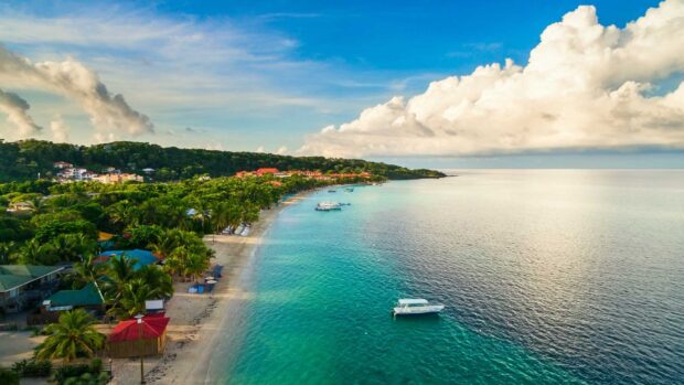 Tropical coastline in Honduras with clear turquoise water and lush green trees