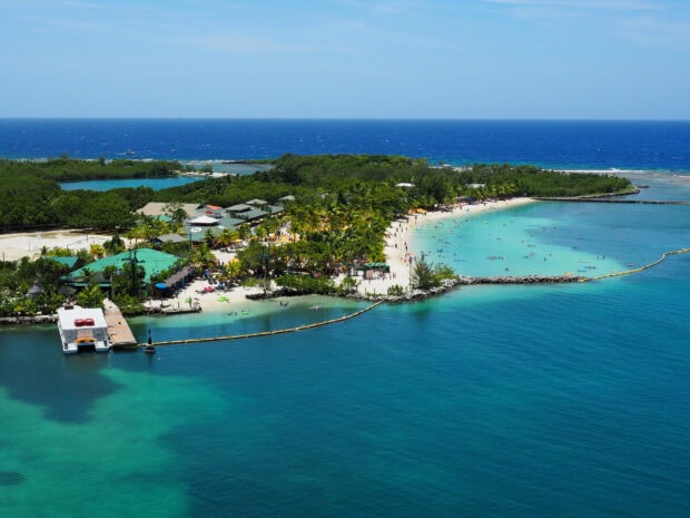 Tropical island with blue water and green trees in Honduras coast