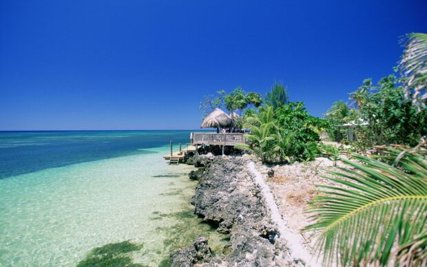 Clear turquoise water and rocky coastline in Honduras tropical beach
