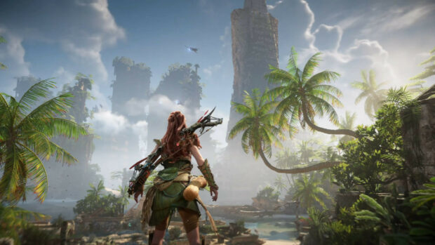 Aloy exploring the forbidden west landscape with towering ruins and lush palm trees in the distance