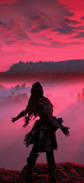 Aloy explores a misty landscape in Horizon Forbidden West with a dramatic red sky