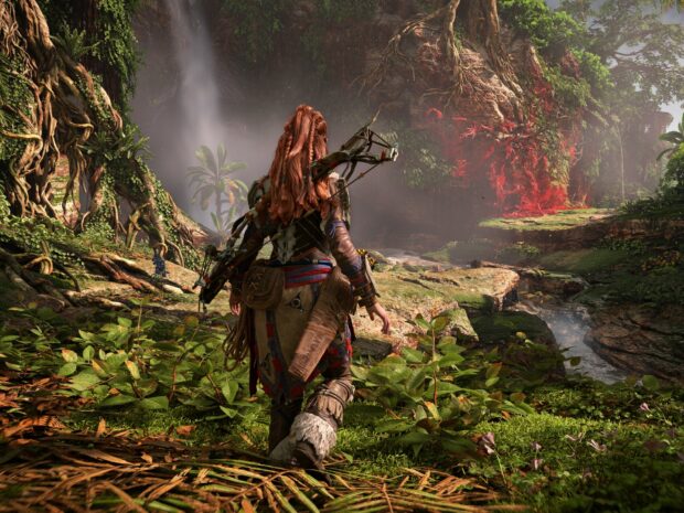 Aloy exploring lush Horizon Forbidden West landscape with vibrant plants and rocky cliffs