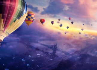 Colorful hot air balloon floating over a misty landscape with a bridge visible below