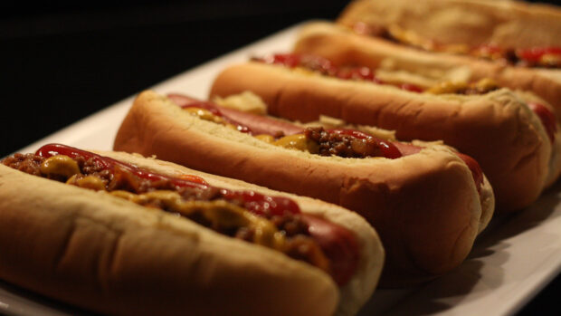 A close up view of hot dog with mustard and ketchup on a plate arranged in a row