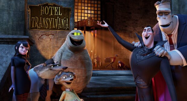 The Hotel Transylvania characters gather happily in front of the hotel entrance