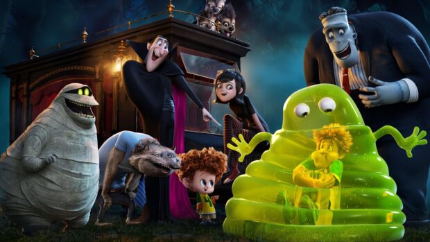 Hotel Transylvania characters including a mummy, vampire, werewolf, and green slime surrounding a boy inside the slime in a spooky outdoor setting