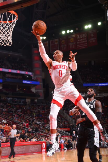 Houston Rockets player jumping for a layup during a basketball game in an indoor arena