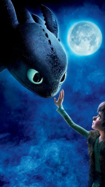 A boy reaching out to a dragon under the full moon in How To Train Your Dragon