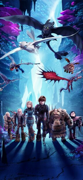 The How To Train Your Dragon characters stand together with dragons flying in a magical cave environment