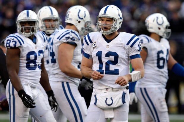 Indianapolis Colts players in white uniforms preparing on the football field during the game
