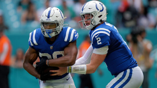 Indianapolis Colts players executing a handoff during a football game in blue uniforms