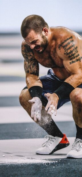 A muscular man applying chalk on his hands before Crossfit training, 2K Mobile Wallpaper