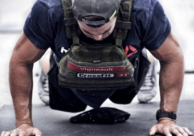 A man performs an intense Crossfit push up wearing a weighted vest, 2K Desktop Wallpaper