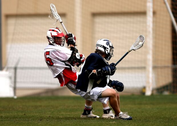 Two players compete closely in a lacrosse game, 2K Desktop Wallpaper