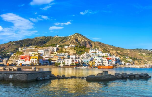 Ischia townscape with colorful buildings and calm sea under clear blue sky