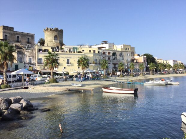 Historic town and waterfront with boats at Ischia island harbor