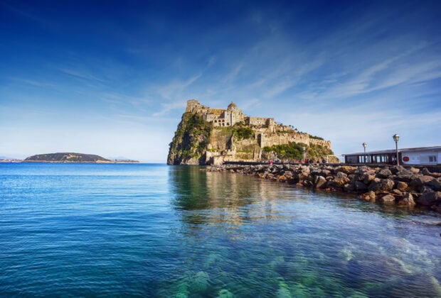 The castle on a rocky cliff in Ischia with clear blue sea and sky in high definition quality