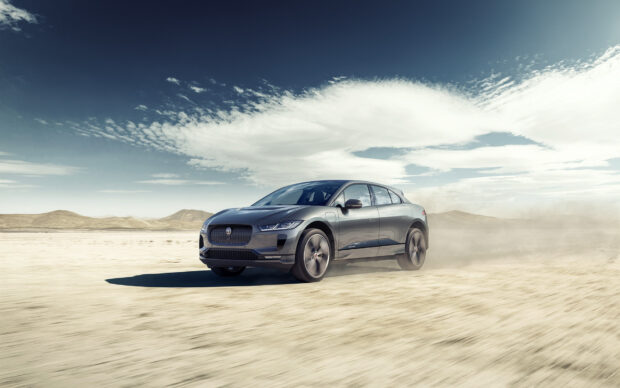 Jaguar I Pace driving fast across a dry desert under a blue sky, HD Desktop Wallpaper