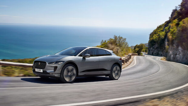 A Jaguar I Pace is driving along a winding coastal road with the ocean in the background, HD Desktop Wallpaper