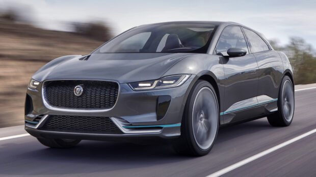 A Jaguar I Pace is moving swiftly on a road with blurred background trees, HD Desktop Wallpaper
