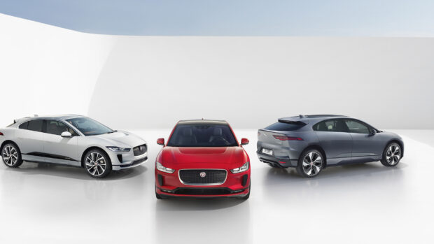 Three Jaguar I Pace electric cars displayed in a bright modern studio, 2K Desktop Wallpaper