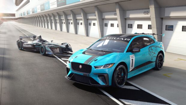 A blue Jaguar I Pace race car and another Jaguar race vehicle parked at the racing pit lane, 4K Desktop Wallpaper
