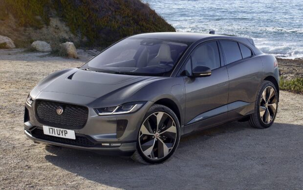A gray Jaguar I Pace is parked near the coastline with waves in the background, HD Desktop Wallpaper