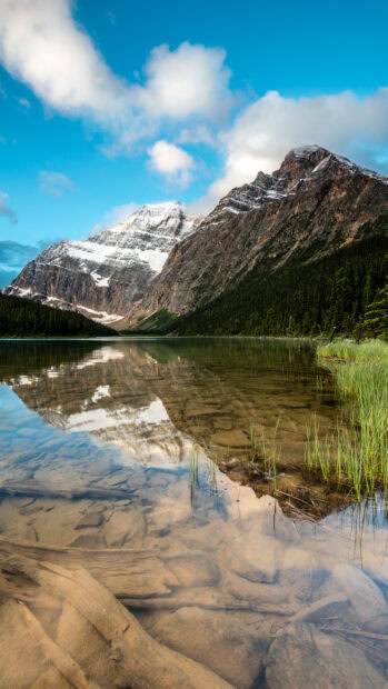 Snow capped mountains and clear lake reflection in Jasper National Park