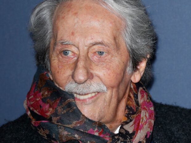 Jean Rochefort smiles warmly wearing a patterned scarf, 2K Desktop Wallpaper