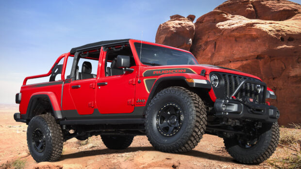 Red Jeep Gladiator Rubicon parked on desert terrain with rocky background