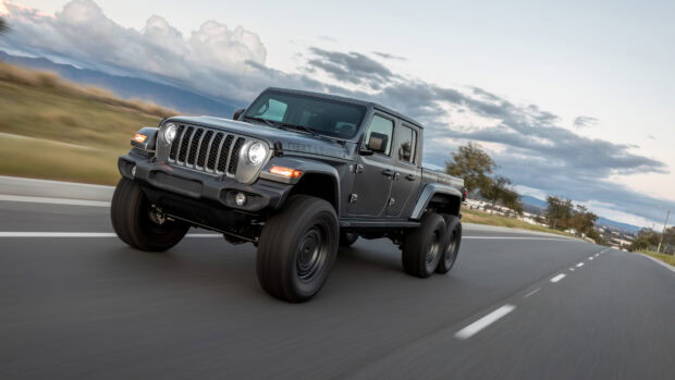 Jeep Gladiator truck driving fast on the highway under a cloudy sky