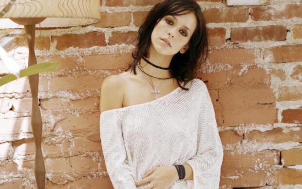 Jennifer Love Hewitt wears a white off shoulder top leaning against a brick wall, HD Desktop Wallpaper