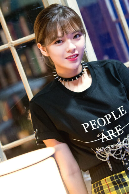 A smiling portrait of Jeongyeon Twice wearing a spiked choker and black graphic t shirt indoors, 2K Mobile Wallpaper