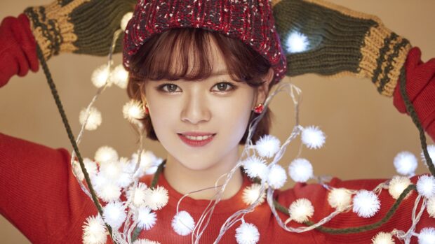A close up of Jeongyeon Twice smiling with holiday lights wrapped around her, 4K Desktop Wallpaper