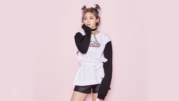A portrait of Jeongyeon Twice wearing a black and white sweater with chains standing against a pink background, HD Desktop Wallpaper