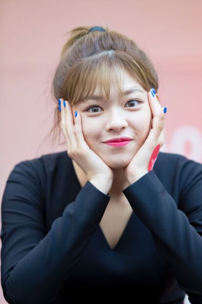 Jeongyeon Twice is smiling warmly while resting her face on her hands in this portrait, HD Mobile Wallpaper