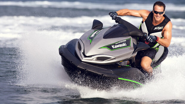 A man is riding a Kawasaki jet ski swiftly over the water surface, HD Desktop Wallpaper