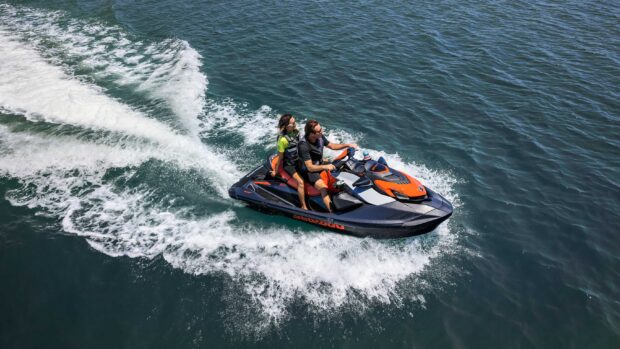 Two people enjoying a jet ski ride on clear blue water, 2K Desktop Wallpaper